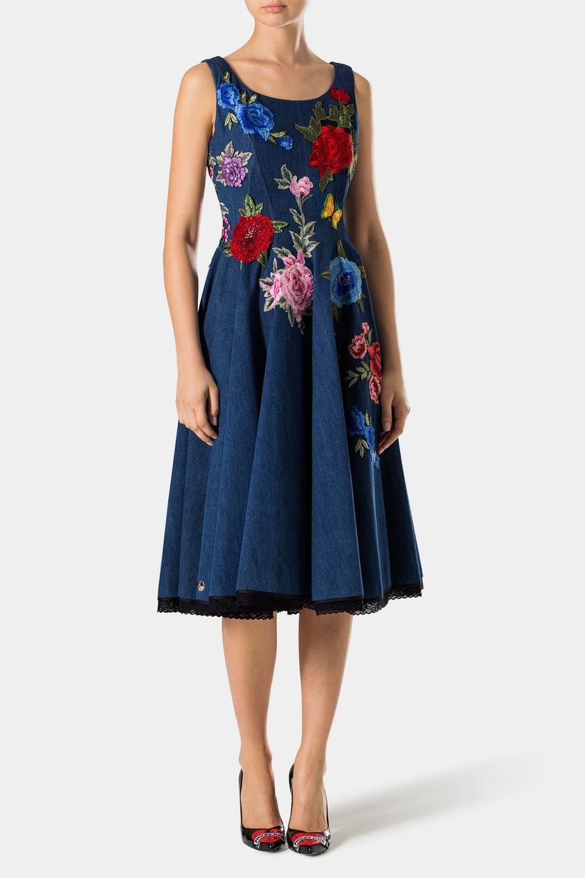 Платье-миди выполнено из денима насыщенного синего цвета. Модель приталенного кроя украшена крупной цветочн